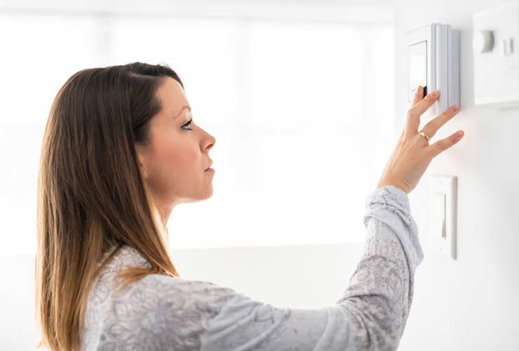 woman setting thermostat